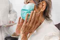 上了年纪的女人穿面具保护冠状病毒新冠病毒