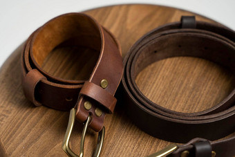 棕色（的）皮革男人的腰带青铜扣木椅子白色背景手工制作的皮革带