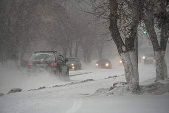 白雪覆盖的路汽车风暴暴雪降雪冬天坏天气城市极端的冬天天气条件北汽车开车白雪覆盖的街道城市