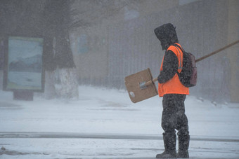 工作男人。市政服务雪铲走路风暴暴雪降雪冬天坏天气城市极端的冬天天气条件北