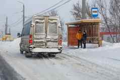 男人。女人等待运输公共汽车停止冬天雪一天图拉俄罗斯