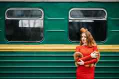 年轻的女孩红色的头发明亮的红色的衣服乘客车