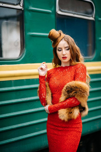 年轻的女孩红色的头发明亮的红色的衣服乘客车