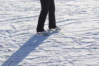 关闭女士脚穿冰滑冰靴子站冰