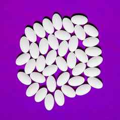 白色药片集团紫色的背景