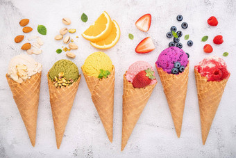 冰奶油味道视锥细胞蓝莓阿月浑子杏仁橙色樱桃设置白色石头背景夏天甜蜜的菜单概念