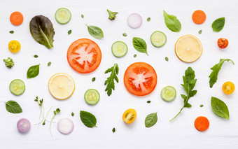 食物模式生成分沙拉生菜叶子黄瓜西红柿胡萝卜西兰花罗勒洋葱柠檬平躺白色木背景