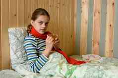 生病的女孩喝茶坐着床上女孩看起来框架