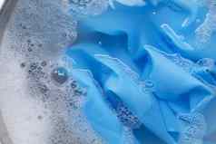 蓝色的衣服浸泡粉洗涤剂水解散洗衣概念