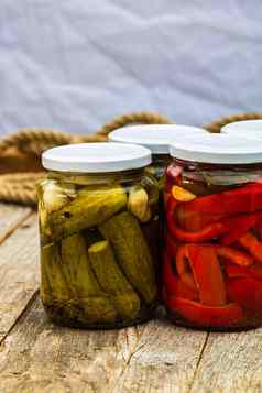 玻璃罐子腌红色的贝尔辣椒腌黄瓜泡菜孤立的罐子各种腌蔬菜保存食物概念乡村作文