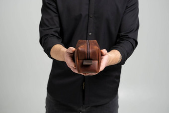 男人的棕色（的）皮革个人化妆品袋袋化妆品附件男人的手黑色的衬衫风格复古的时尚古董优雅
