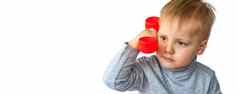肖像惊讶可爱的男孩持有红色的电话接收机孩子孤立的白色背景概念广告横幅