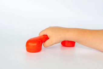 红色的玩具电话孩子的手特写镜头孩子的手孤立的白色背景概念广告横幅