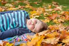 孩子们玩秋天公园很多黄色的叶子男孩谎言枫木叶子秋天树叶