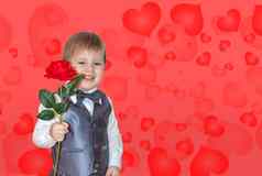 男孩持有手红色的玫瑰概念情人节一天主题肖像可爱的男孩西装弓领带