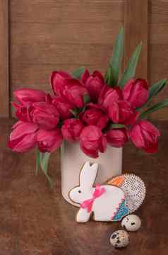 粉红色的郁金香复活节兔子饼干木背景
