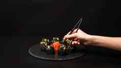 手筷子自定义寿司卷黑色的大米蟹肉鳄梨烟熏大马哈鱼摩丝桨鱼子酱大规模虾鸡尾酒可食用的黄金叶姜芥末酱黑色的表格