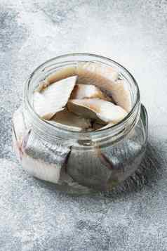 大西洋野生鲱鱼腌罐头鱼保存玻璃Jar灰色的背景