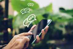 人手智能手机打字聊天文本消息闲谈，聊天图标流行社会媒体市场技术概念