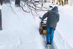 男人。清洁车道雪机器雪风暴雪删除设备工作街清洁街道雪下雪