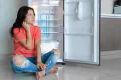 女孩惊讶空冰箱缺乏食物食物交付