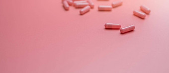 粉红色的胶囊药丸传播粉红色的背景维生素补充健康的皮肤胶原蛋白提高痤疮治疗概念在线药店药店商店横幅制药行业