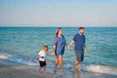 妈妈。父亲孩子支出时间家庭假期父爸爸妈妈走儿子享受海海滩