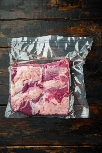熏牛肉肉包装真空塑料袋黑暗木表格背景前视图平躺
