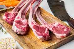 新鲜的生屠夫羊肉牛肉片成分胡萝卜橙色草本植物屠夫切肉刀刀白色石头背景