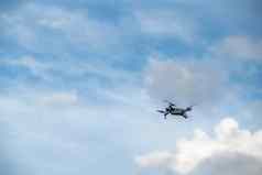 飞行飙升的无人机天空蓝色的天空白色云阳光明媚的天气把螺旋桨