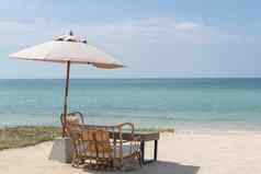 表格椅子伞集浪漫的餐海滩天空海背景