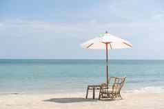 表格椅子伞集浪漫的餐海滩天空海背景
