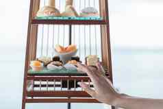 女人手集奢侈品传统的下午茶甜点服务鸟笼子里