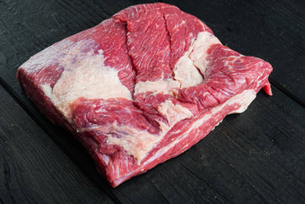 生胸肉牛肉减少黑色的安格斯牛肉黑色的木表格背景复制空间文本