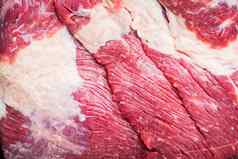 新鲜的未煮过的生肉牛肉胸肉黑色的木表格背景前视图平躺