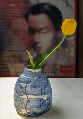 黄色的花蓝色的陶瓷花瓶白色变形表格布前面经典中国人海报电影框架