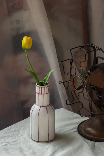 黄色的花白色手工制作的<strong>陶瓷花瓶</strong>古董风扇白色变形表格布水泥墙