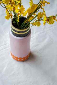 花束黄色的花手工制作的陶瓷花瓶古董风扇白色变形表格布
