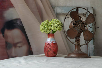 花束绿色花红色的手工制作的陶瓷花瓶古董风扇白色变形表格布前面经典中国人海报电影框架水泥墙