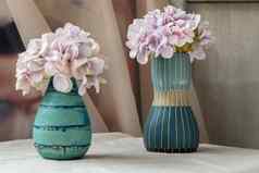 花束紫色的花蓝色的手工制作的陶瓷花瓶白色变形表格布