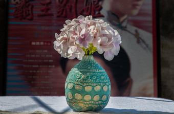 花束紫色的花蓝色的手工制作的陶瓷花瓶白色变形表格布前面经典中国人海报电影框架