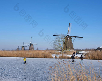人滑冰冰小孩堤防很多风车荷兰阳光明媚的冬天一天
