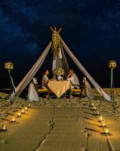 夫妇但女人浪漫的晚餐蜡烛灯海滩泰国欧洲但亚洲女人晚餐海滩情人节概念