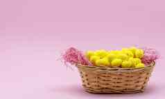 黄色的复活节蛋雀斑模式内部篮子粉红色的背景