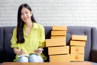 年轻的亚洲女人企业<strong>家电</strong>话写作订单客户在线笔记本<strong>首页</strong>在线购物物流交付女卖方工作沙发业务锻造