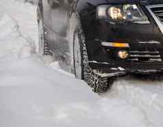 黑色的车辆移动深雪轮滑车子吧轮自旋排放块雪尝试获得牵引湿滑的路