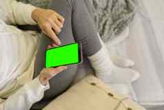 无聊女孩坐着依偎毯子沙发垫子指出智能手机绿色屏幕nodern次首页习惯浪费时间互联网社会网络