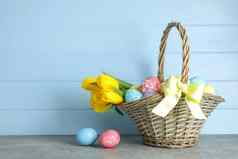 复活节篮子填满色彩斑斓的鸡蛋花木背景