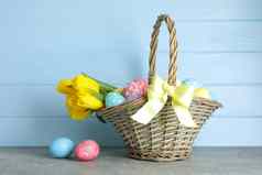 复活节篮子填满色彩斑斓的鸡蛋花木背景