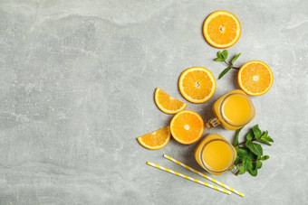 平躺作文橙色块薄荷小管玻璃罐子新鲜的橙色汁灰色背景空间文本新鲜的自然饮料